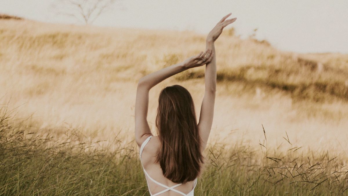 
a-woman-enjoying-the-breeze-in-a-field
