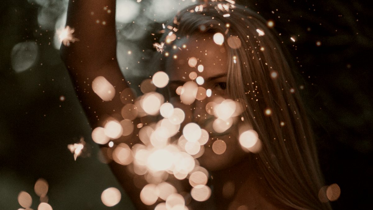 
a-woman-holding-up-two-sparklers
