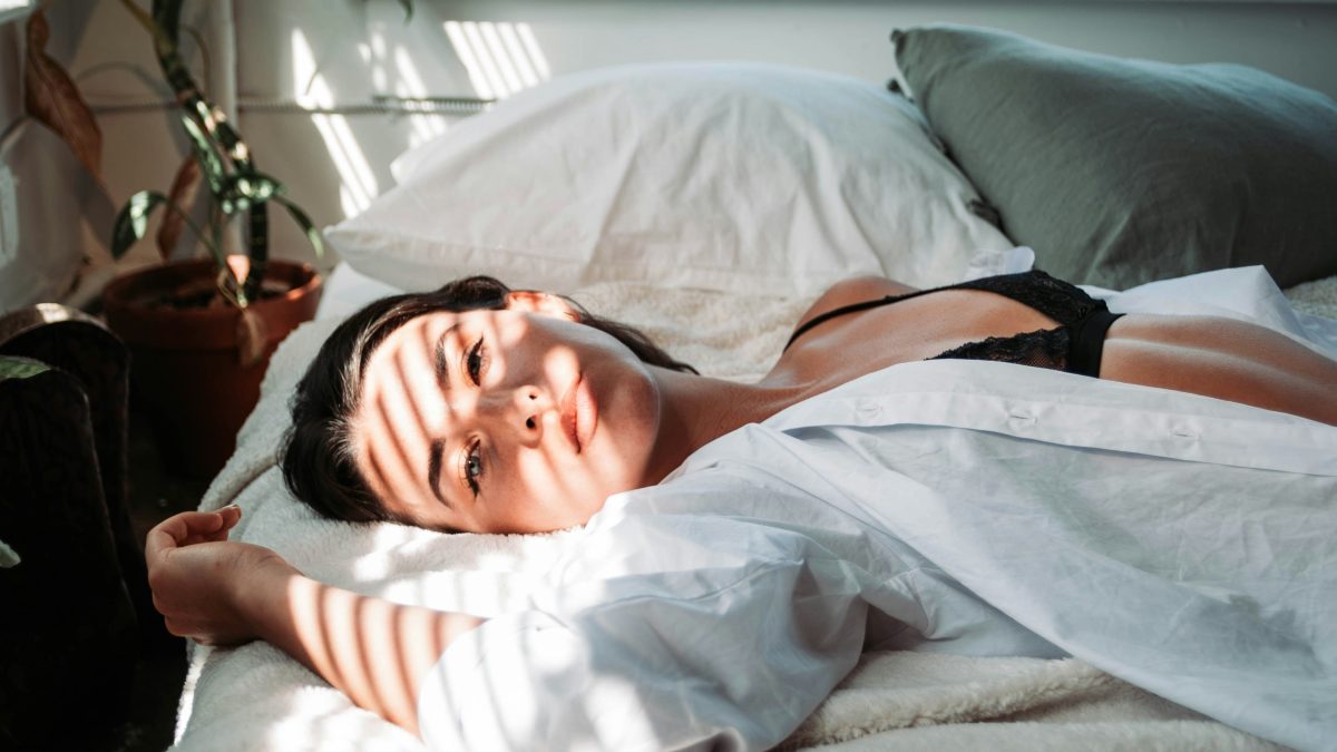 
a woman laying in bed pondering her desire for breakup sex
