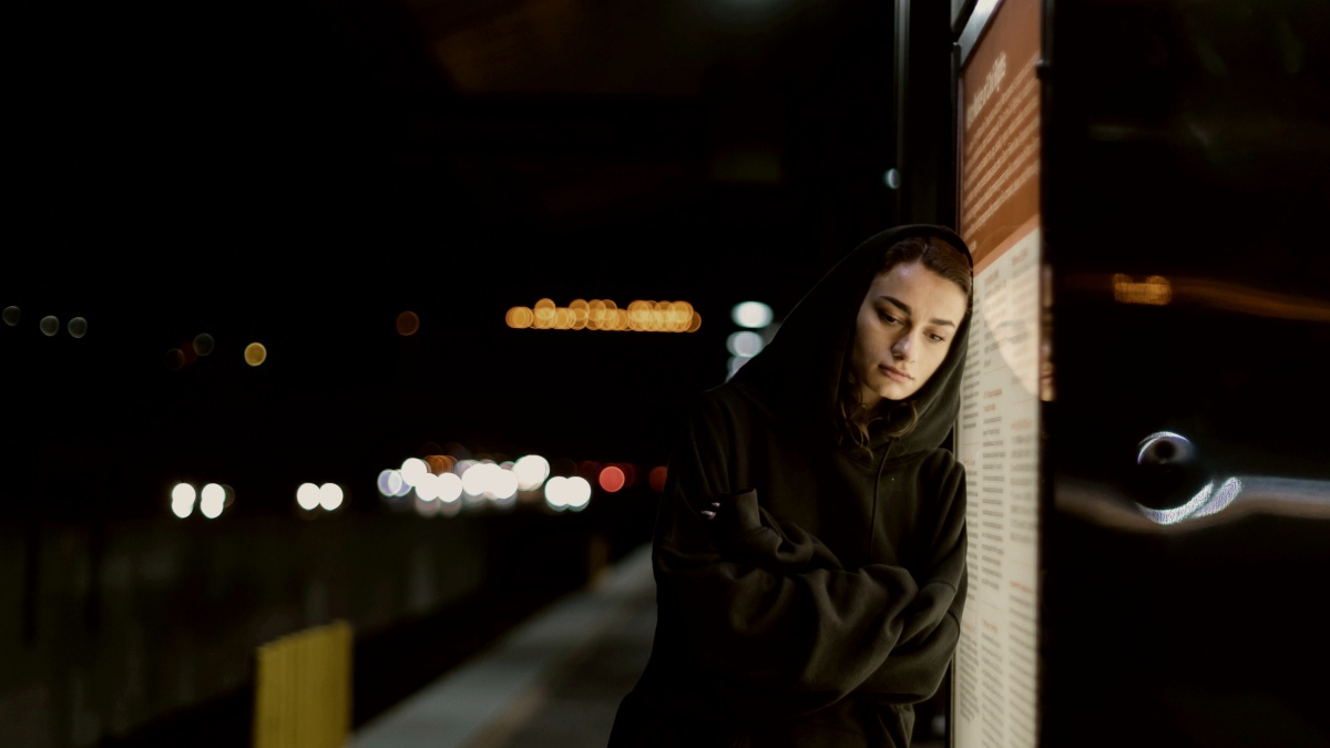 
a woman leaning against a wall in a train station by Meg Aghamyan
