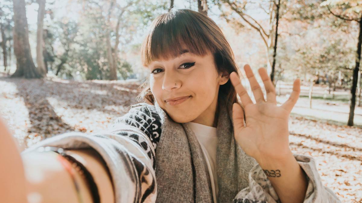 
a woman on facetime holding her hand out in the air
