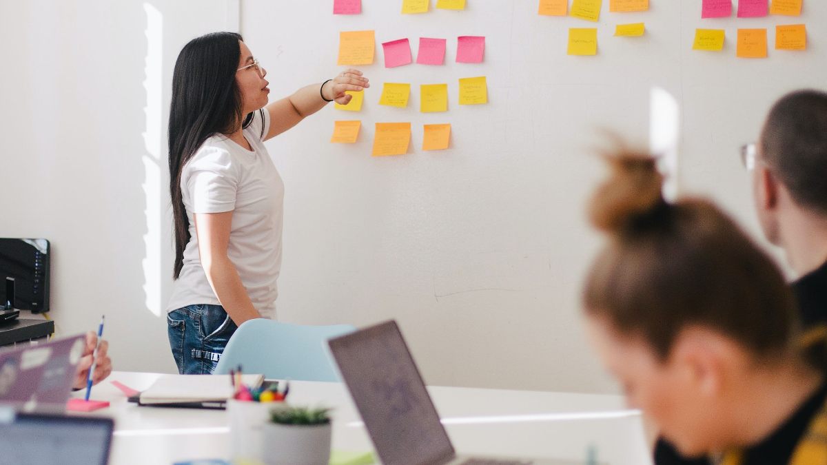 
a woman presenting her ideas in front of her work colleagues
