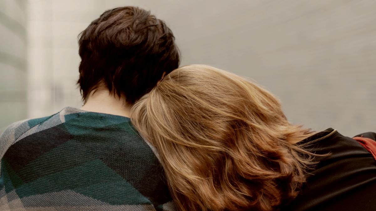 
a woman rests her head on another person's shoulder by Transly Translation Agency
