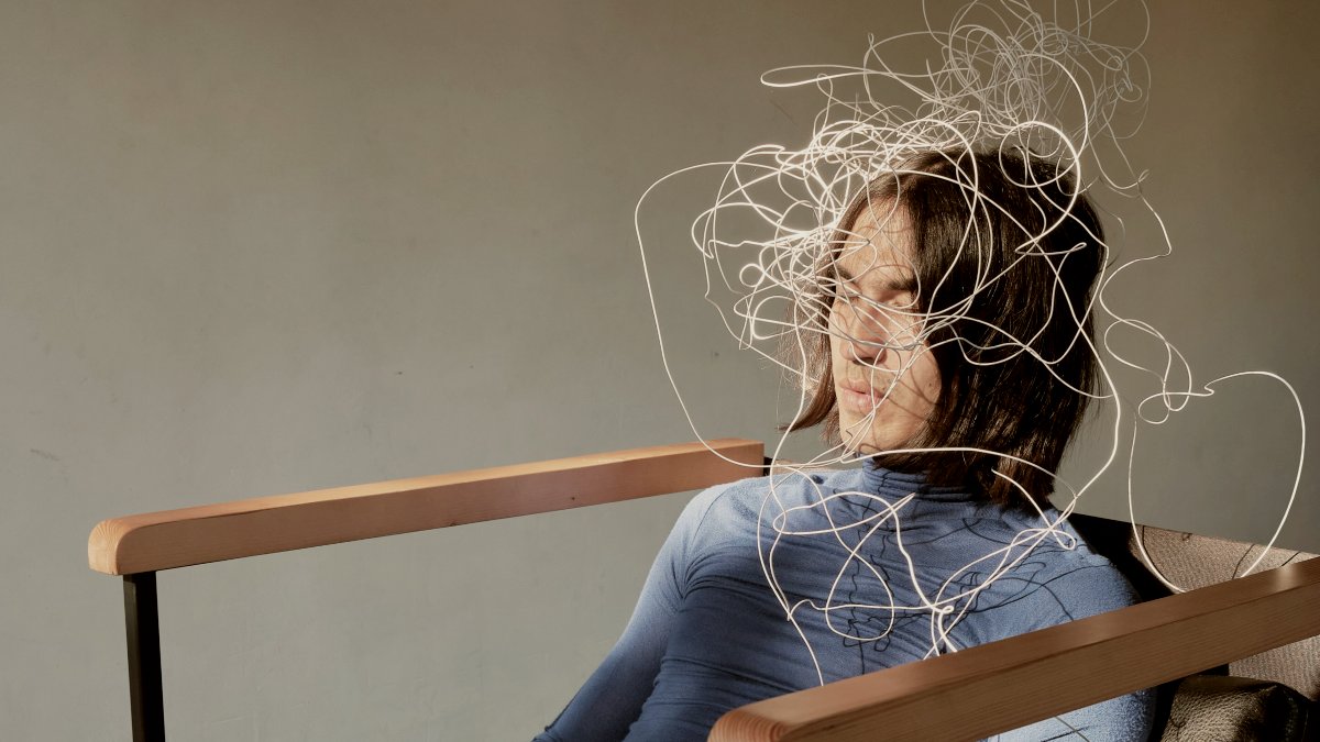 
a woman sitting in a chair in front of a window with wires on her head by Andrej Lišakov

