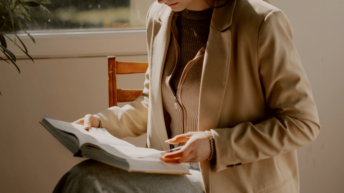 
a-woman-sitting-in-a-chair-reading-a-book
