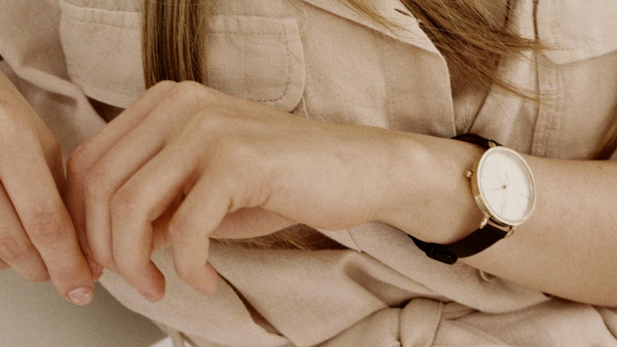 
A woman sitting on a white chair wearing a watch
