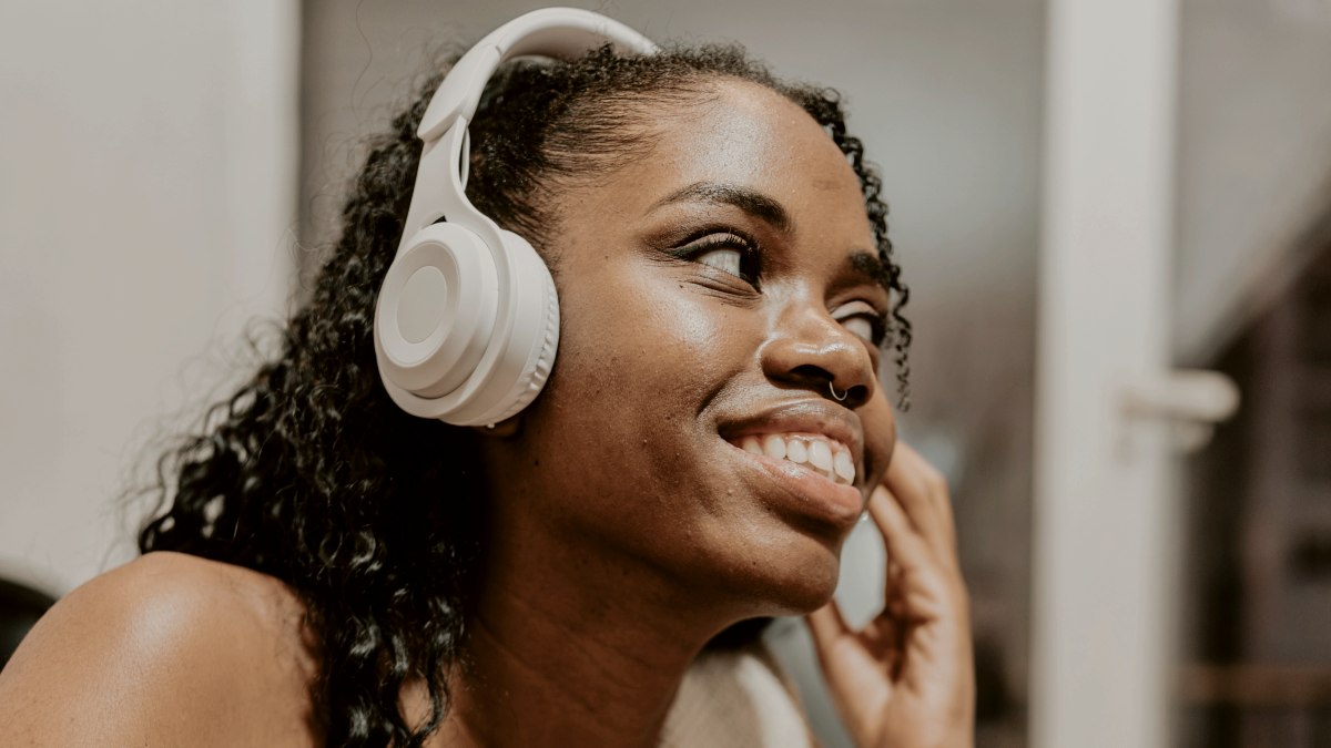 
a woman sitting on the gym floor listening to music with headphones
