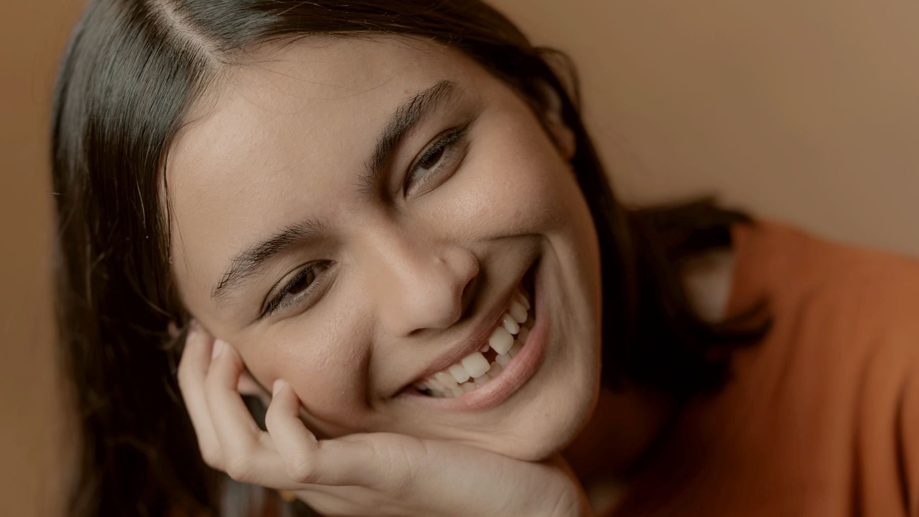 
a woman smiling with her hand on her chin and gap in her teeth by Jordan González
