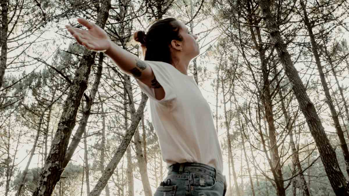 
a woman spreading her arms rejoicing her freedom
