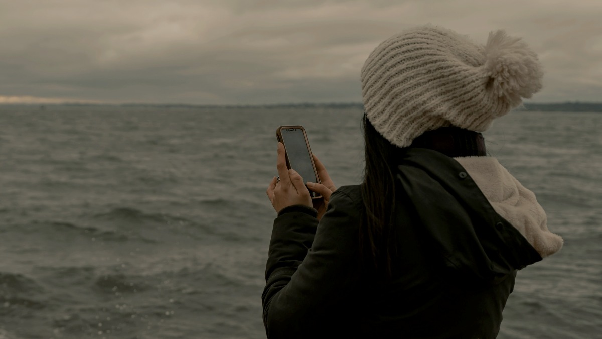 
a-woman-texting-on-the-beach
