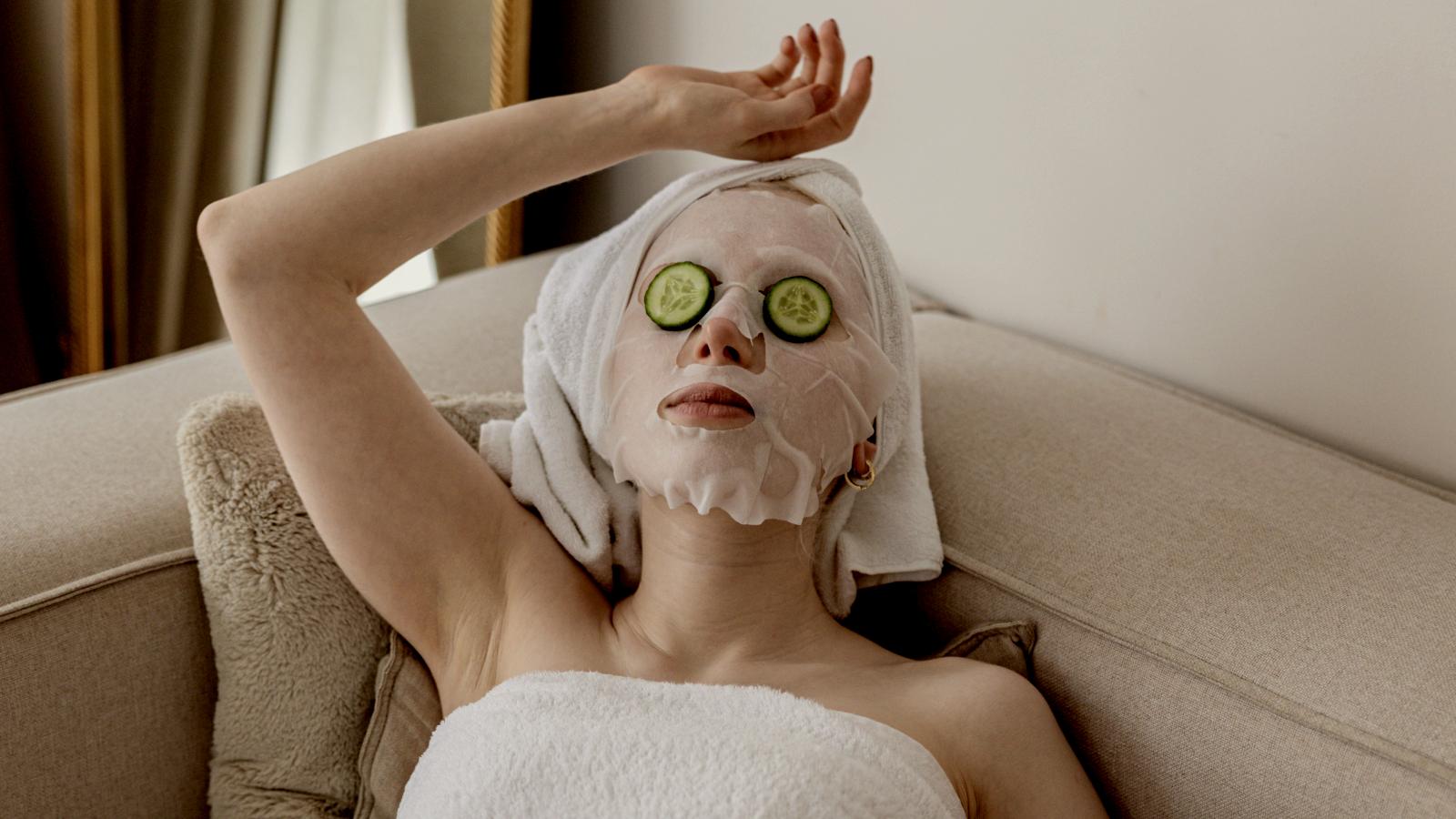 
a woman with cucumber slices on her face and a towel on her head by Faruk Tokluoğlu
