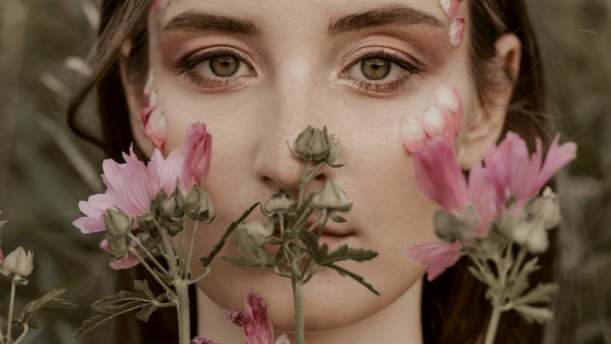 
a woman with flowers around her face
