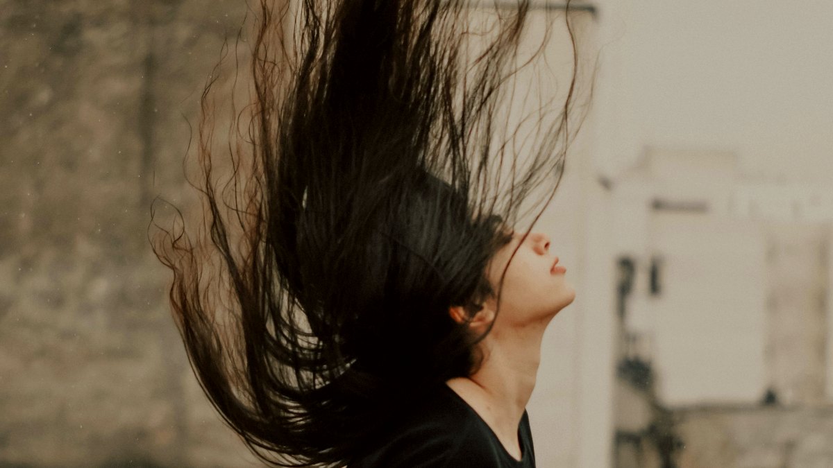 
a woman with her hair blowing in the wind by Negar Nikkhah
