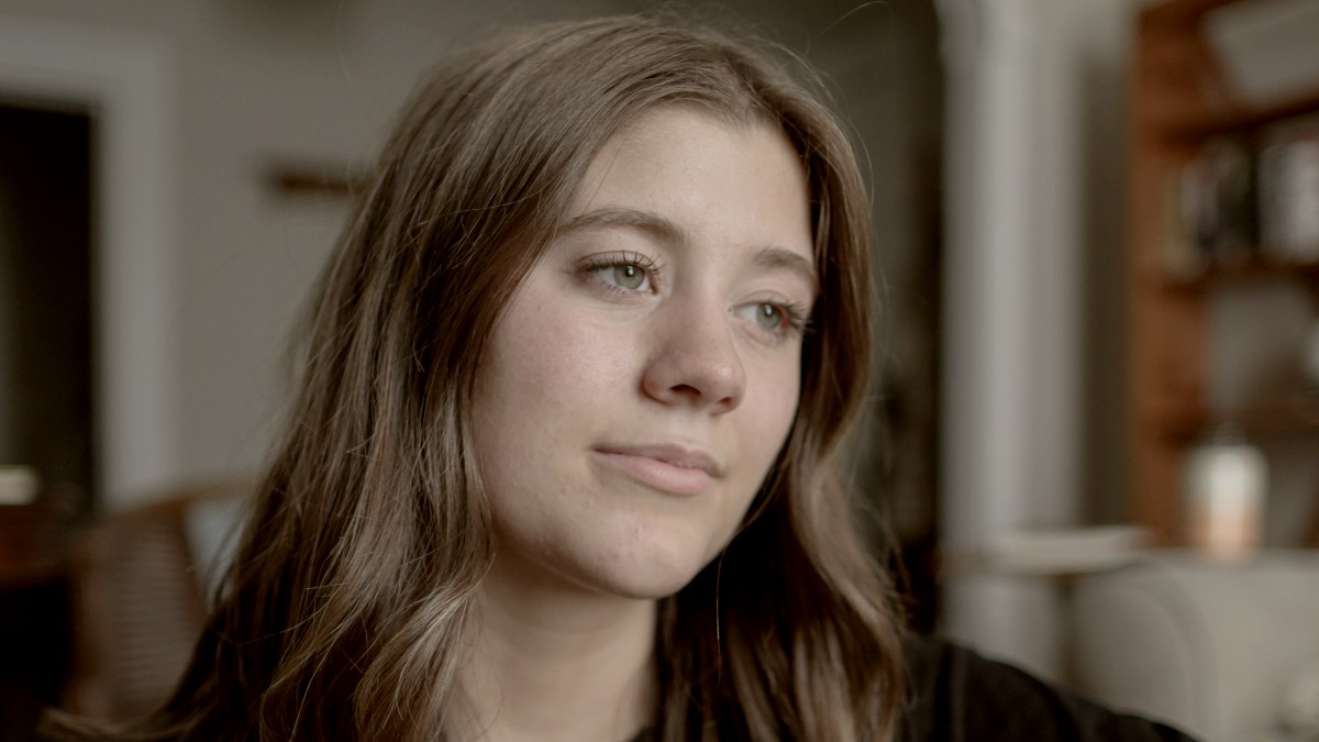 
a woman with longish brown hair standing next to a counter by Blake Cheek
