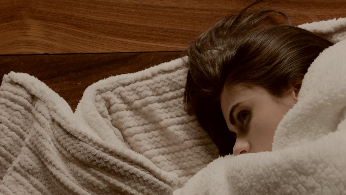 
a woman wrapped in a blanket on a hardwood floor by Pablo Merchán Montes
