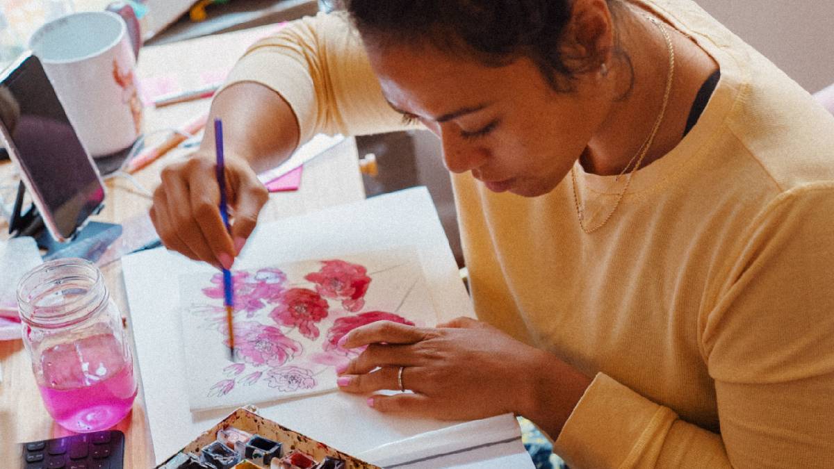 
A young creative woman painting with watercolors to calm her mind.
