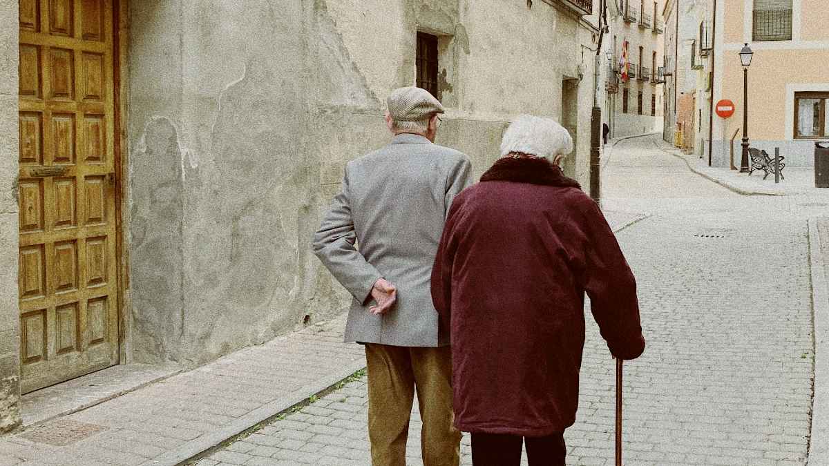 
an-elderly-couple-walking-down-a-path-together
