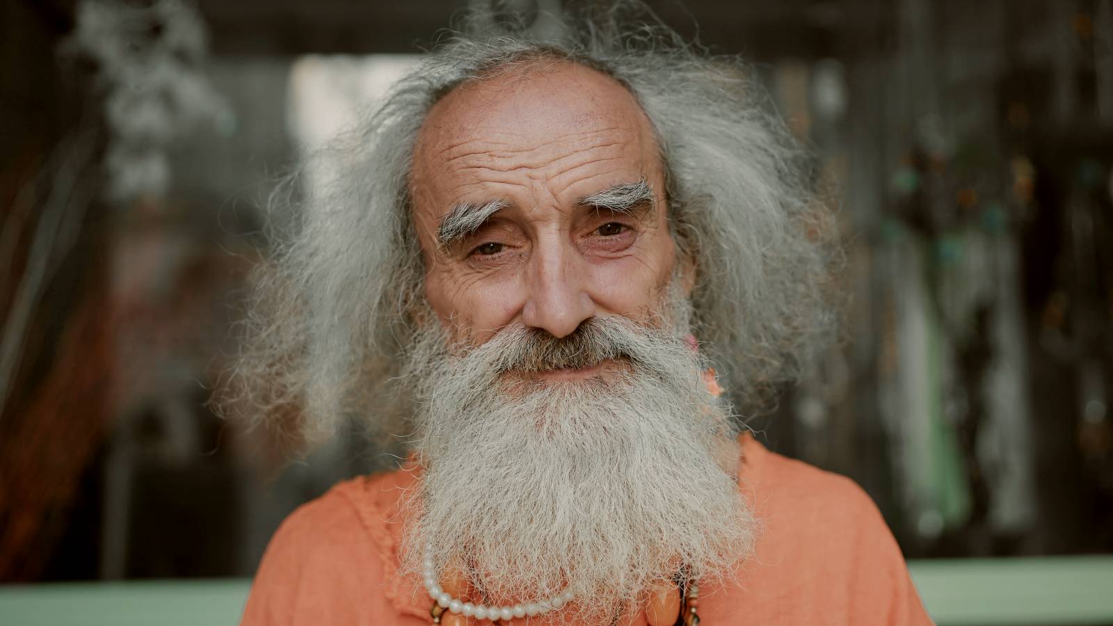 
an old man with a long beard wearing a necklace by Yunus Tuğ
