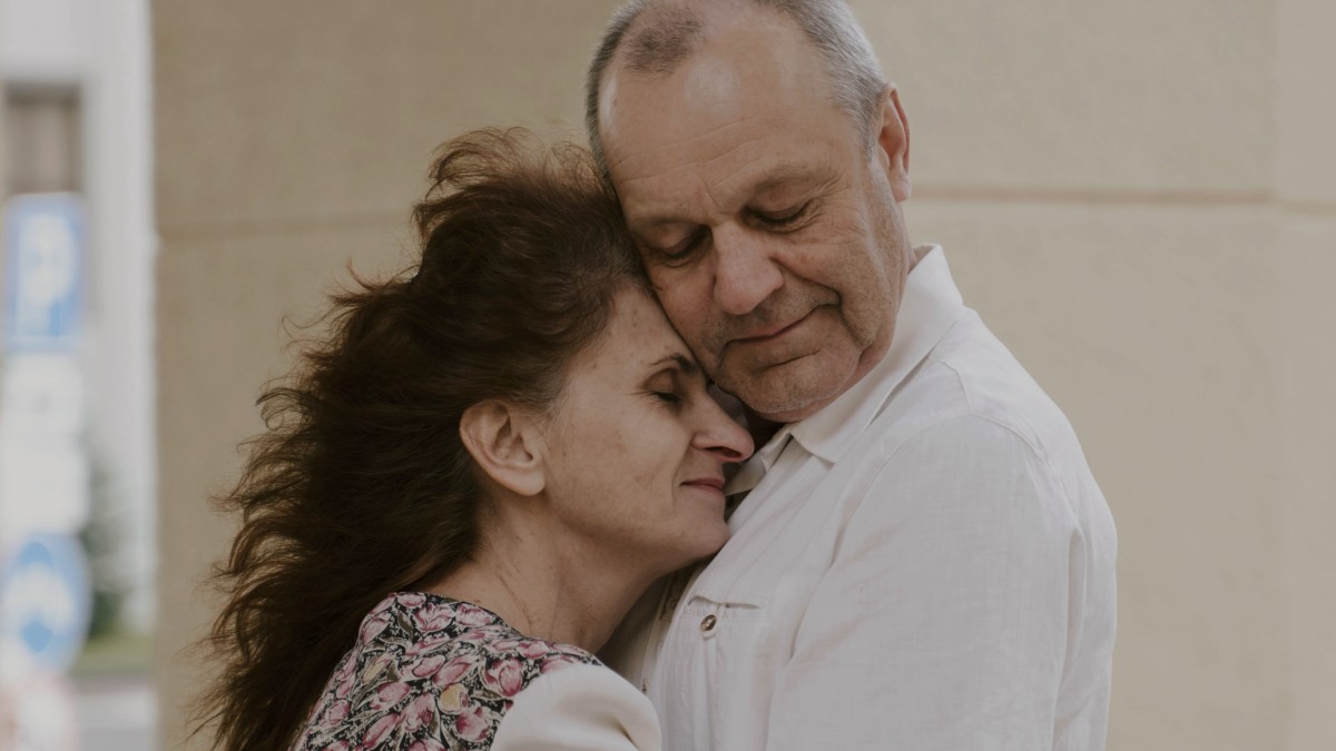
an older couple in an embrace outside by Polina Kuzovkova
