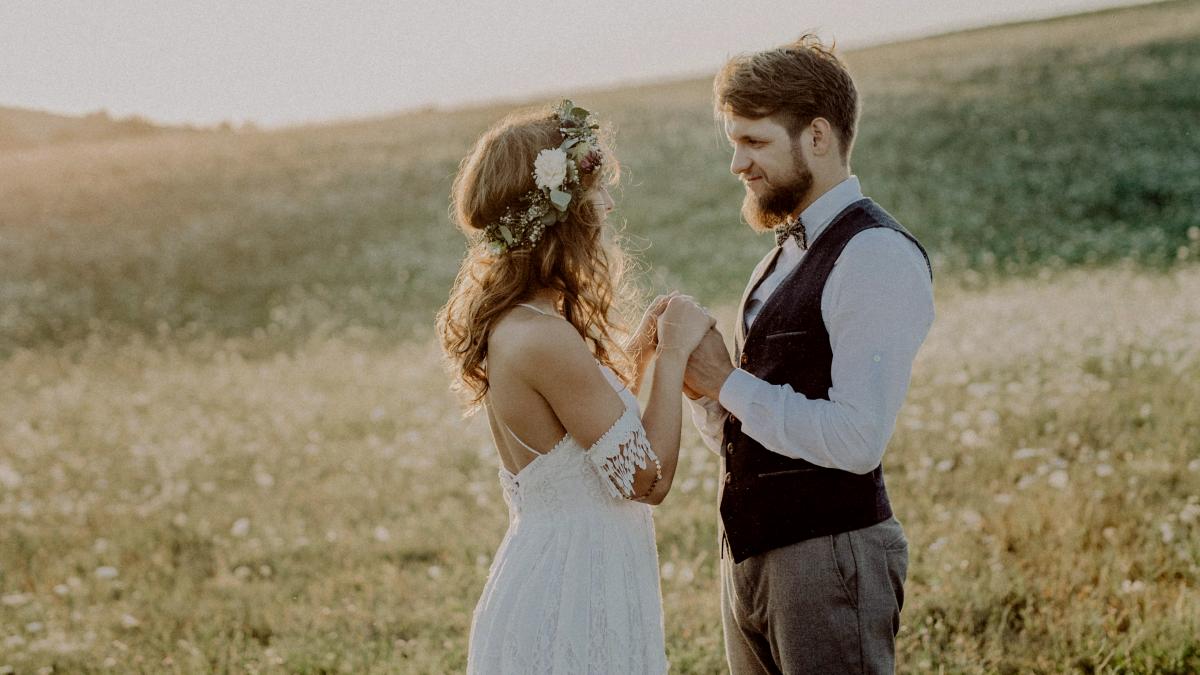 
Beautiful young bride and groom outside in green nature at romantic sunset
