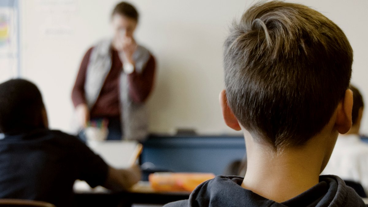 
boy in black hoodie sitting on chair in classroom by Taylor Flowe
