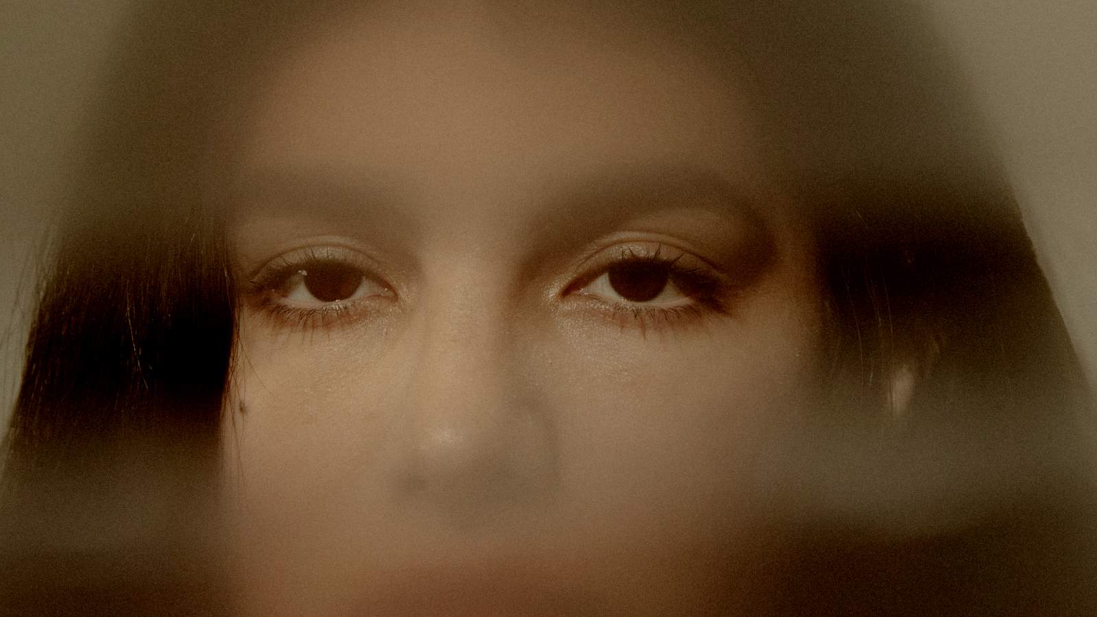 
Close-up of a young woman's face through glass by Frank Flores
