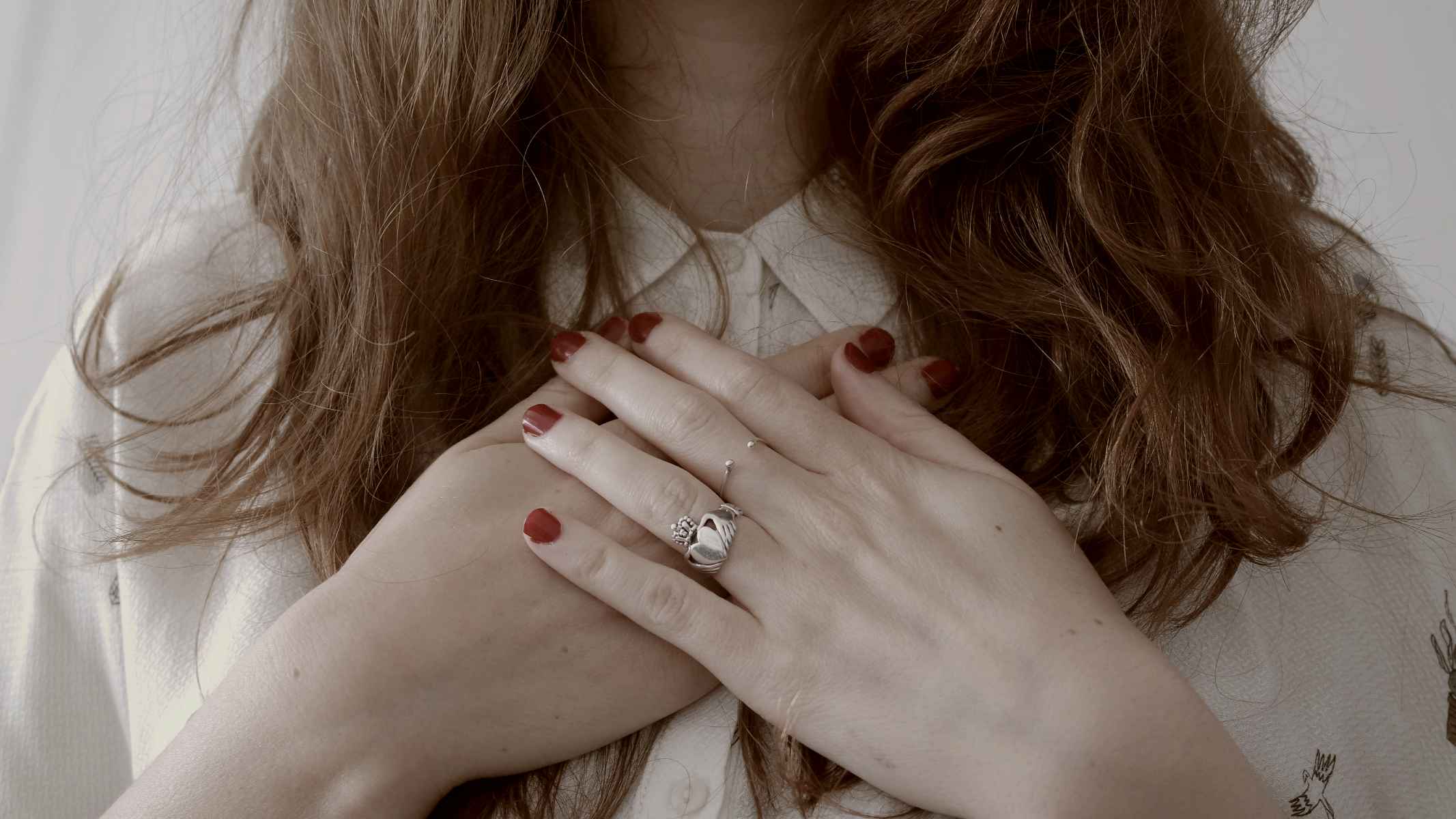 
close up of woman wearing silver-colored ring, hand over her chest by Giulia Bertelli
