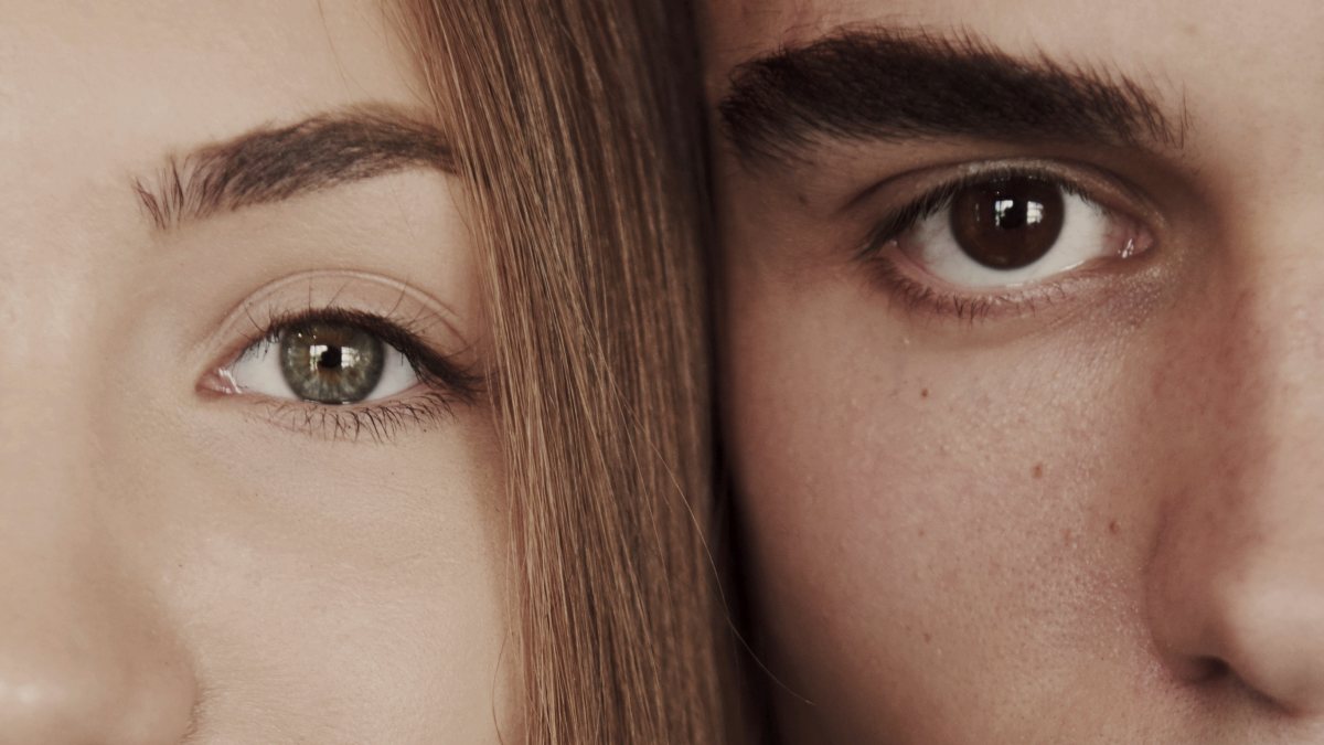 
Close up portrait of half faces man and woman looking at camera
