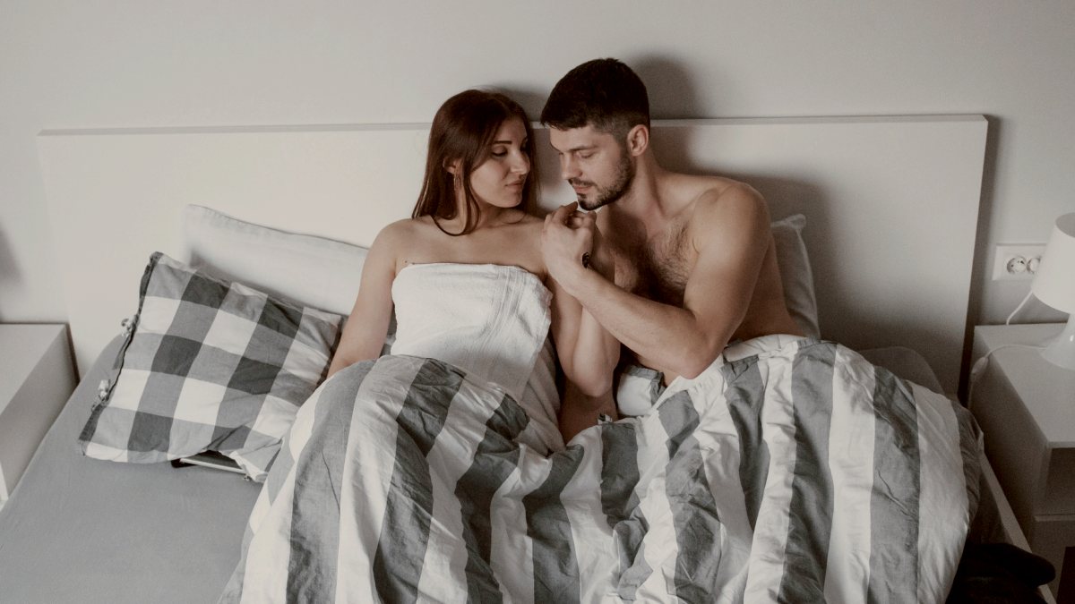 
couple lying on the bed and enjoying themselves at morning time
