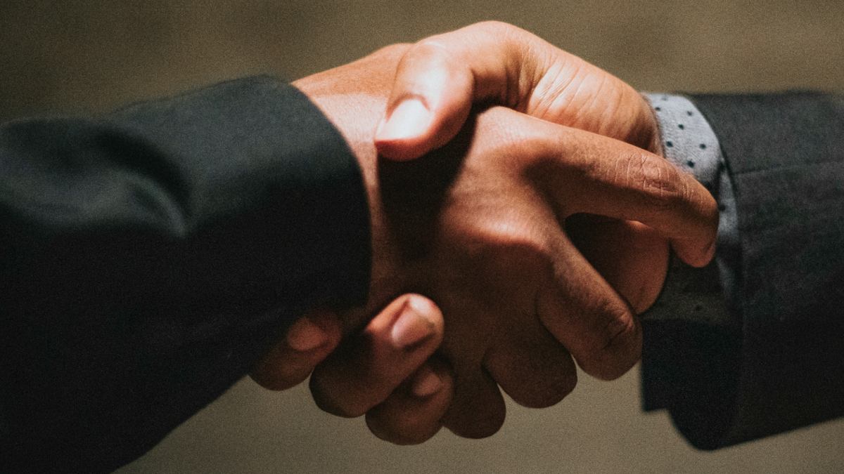 
employee shaking leaders hand after flattering him
