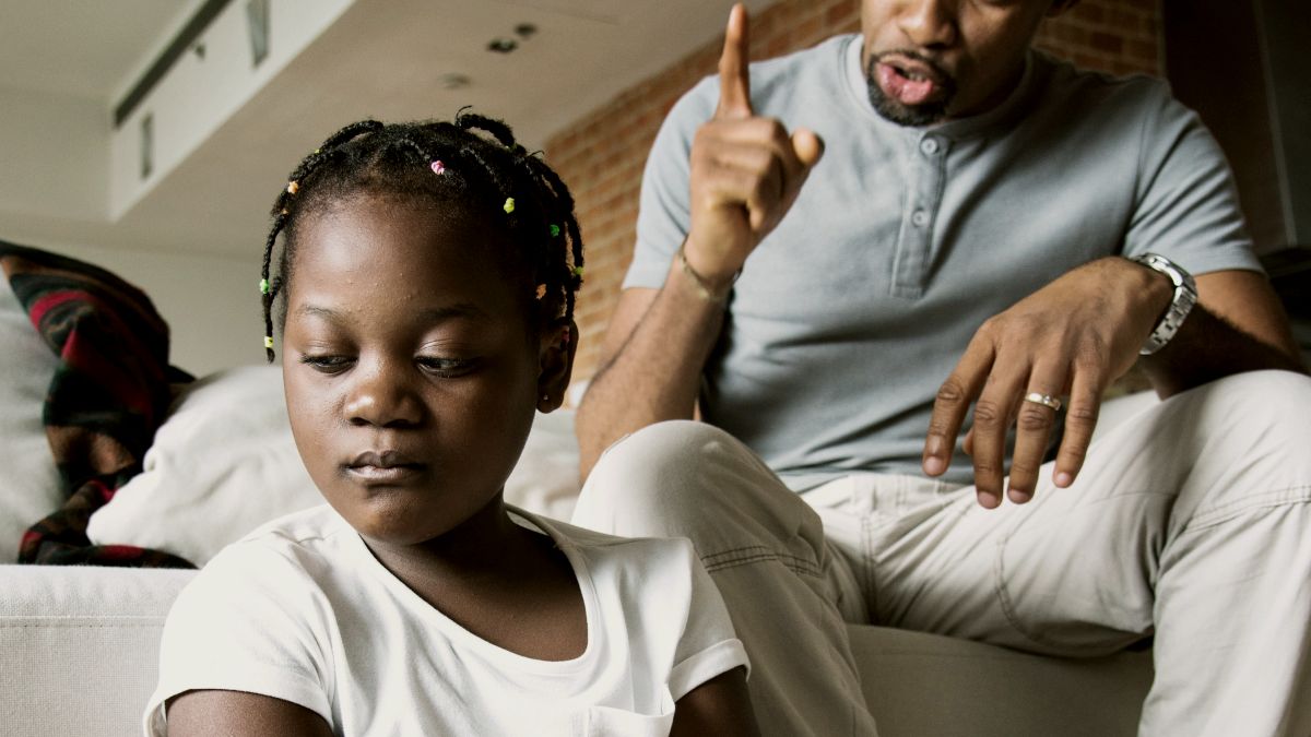 
Father disciplining his daughter with arms crossed by curated lifestyle
