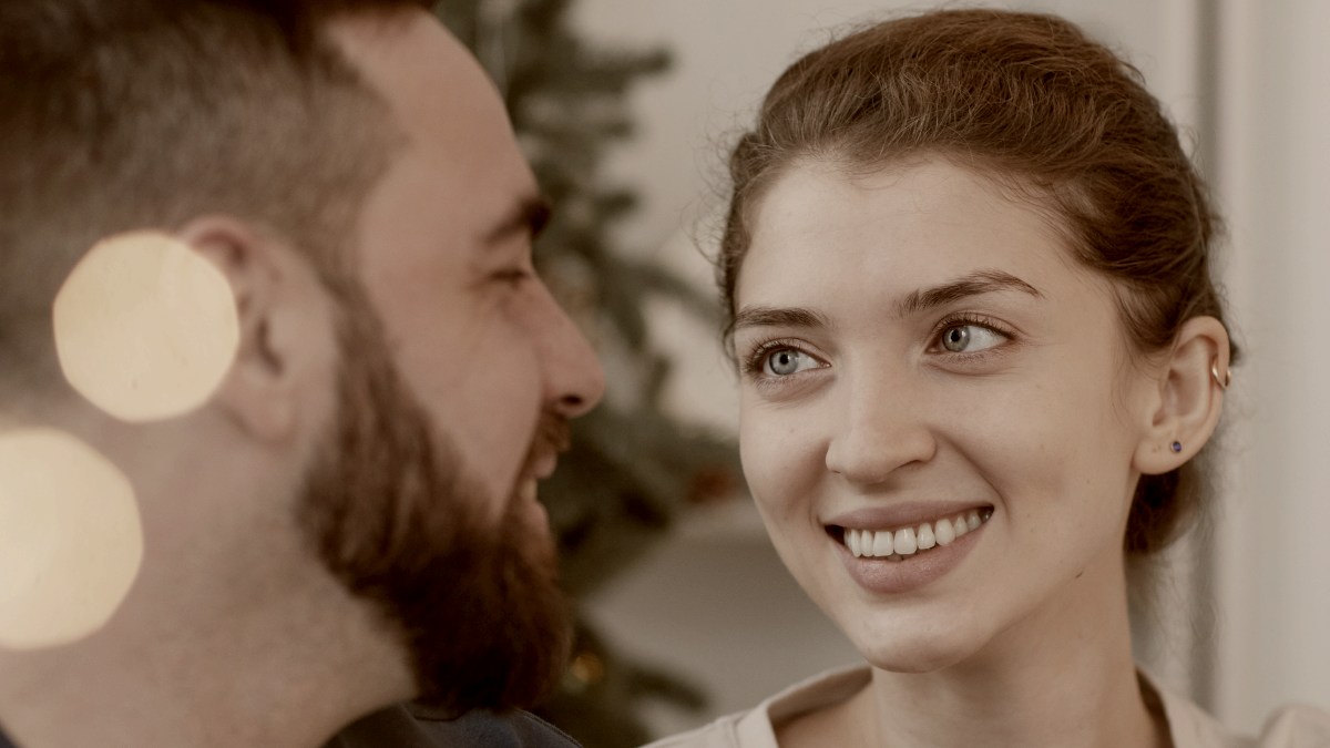 
Happy young caucasian woman looking with love at boyfriend while they celebrating Christmas by Getty Images
