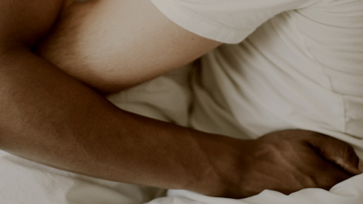 
interracial gay couple sharing a kiss in a bed by Curated Lifestyle

