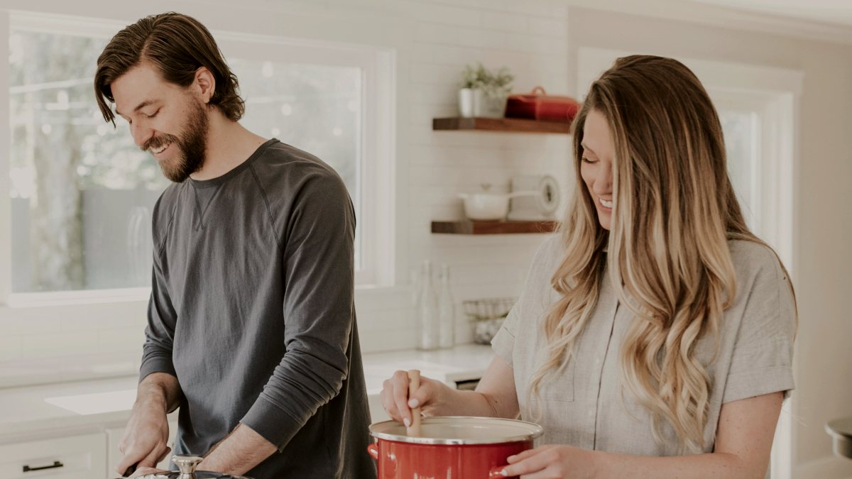 
man and woman cooking together in the kitchen
