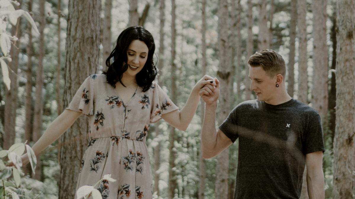 
man holding hands with woman near trees
