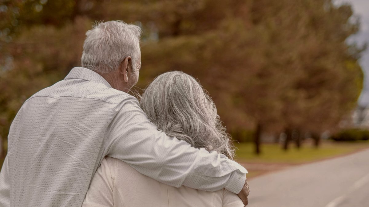 
older couple walking on the road during daytime by Hector Reyes
