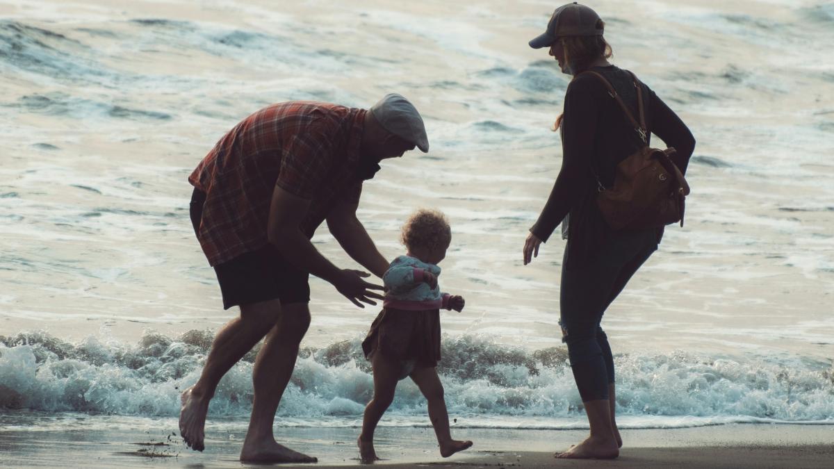 
parents-on-the-beach-with-their-toddler
