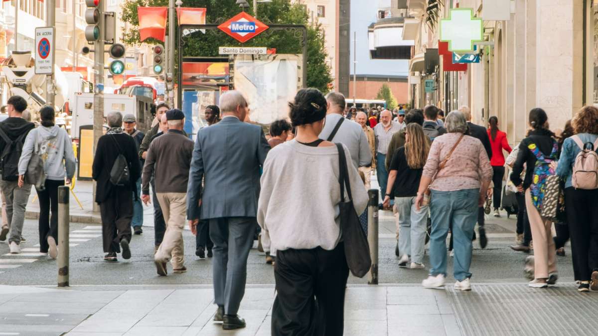 
People walking on a sunny city street sidewalk by Elena Helade
