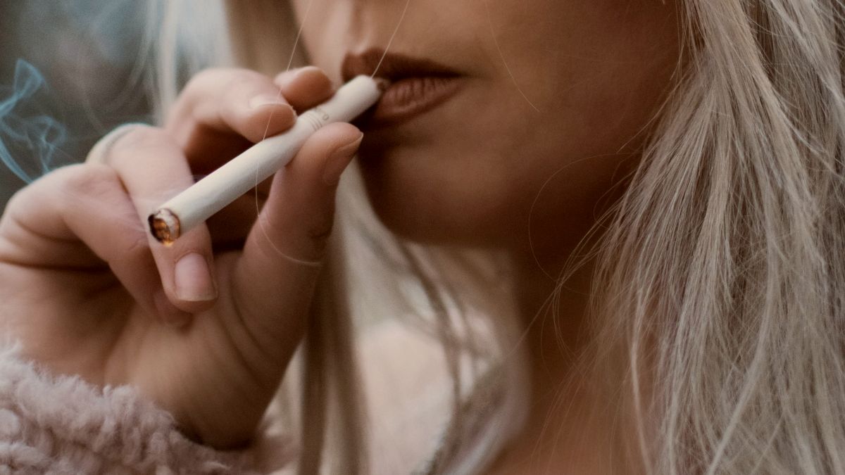 
person-holding-cigarette-stick-wearing-eyeglasses
