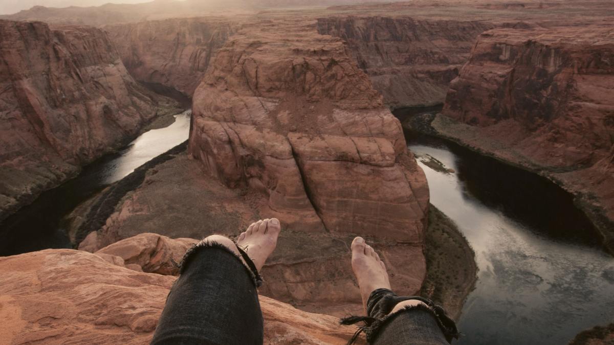 
person sitting on brown mountain cliff
