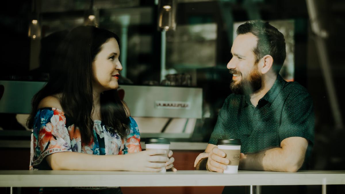 
Romantic partners talking in a coffee shop sharing their thoughts and feelings.
