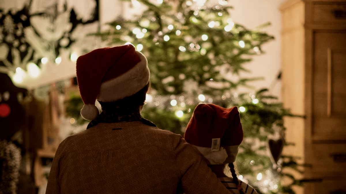 
selective focus photography of girl and woman hugging each other in front of christmas tree by S&B Vonlanthen
