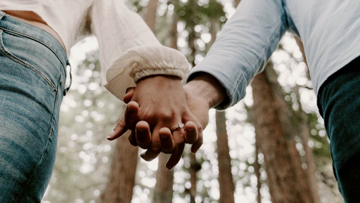 
shallow focus photo of man and woman holding each others hands
