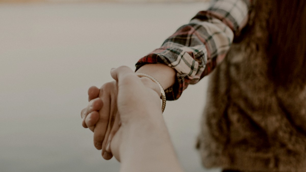 
shallow focus photography of man and woman holding hands by Brooke Cagle
