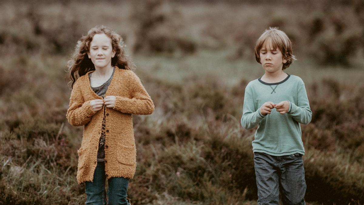 
two-children-standing-together-in-a-field
