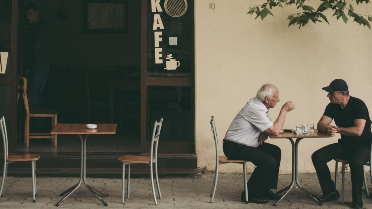 
two-men-having-a-lively-debate-at-a-cafe
