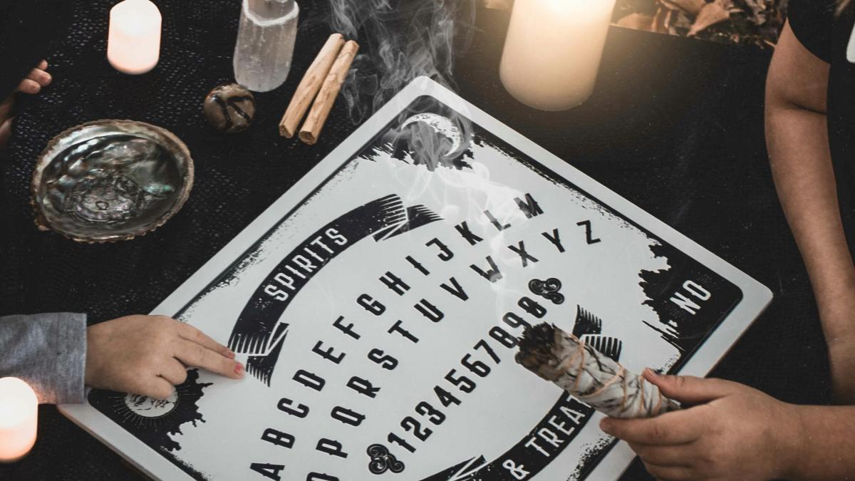 
two-people-engaging-in-after-death-communication-with-a-ouija-board
