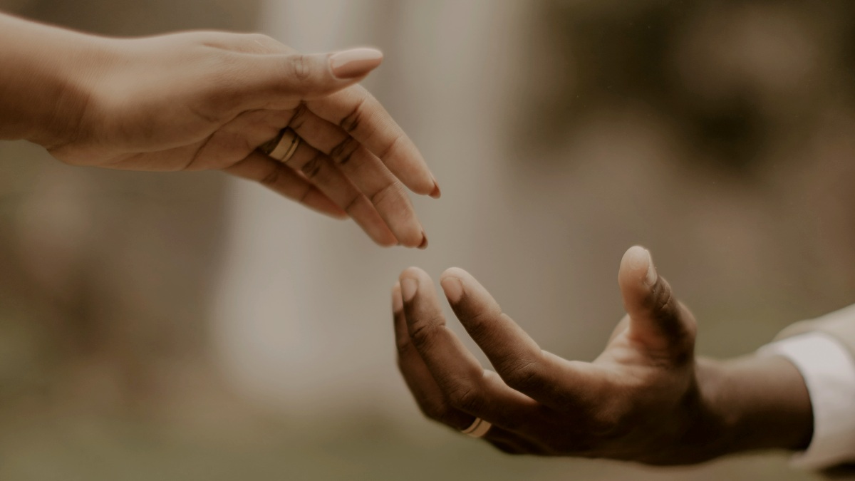 
two people reaching out their hands to each other
