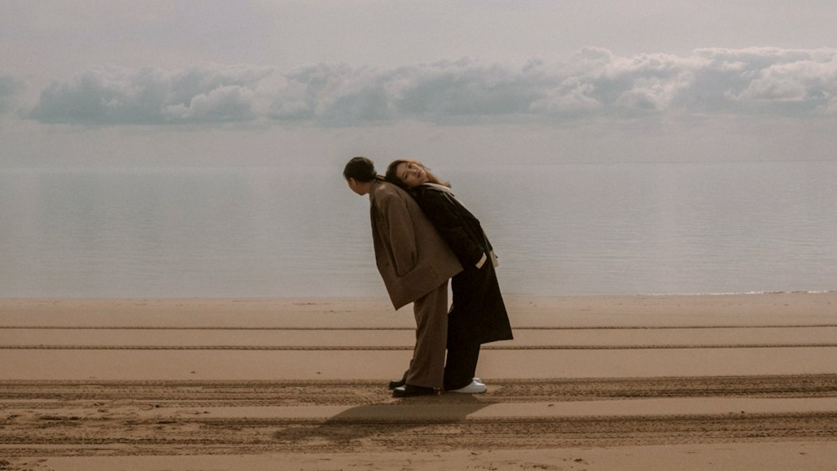 
two women bending over against each others backs
