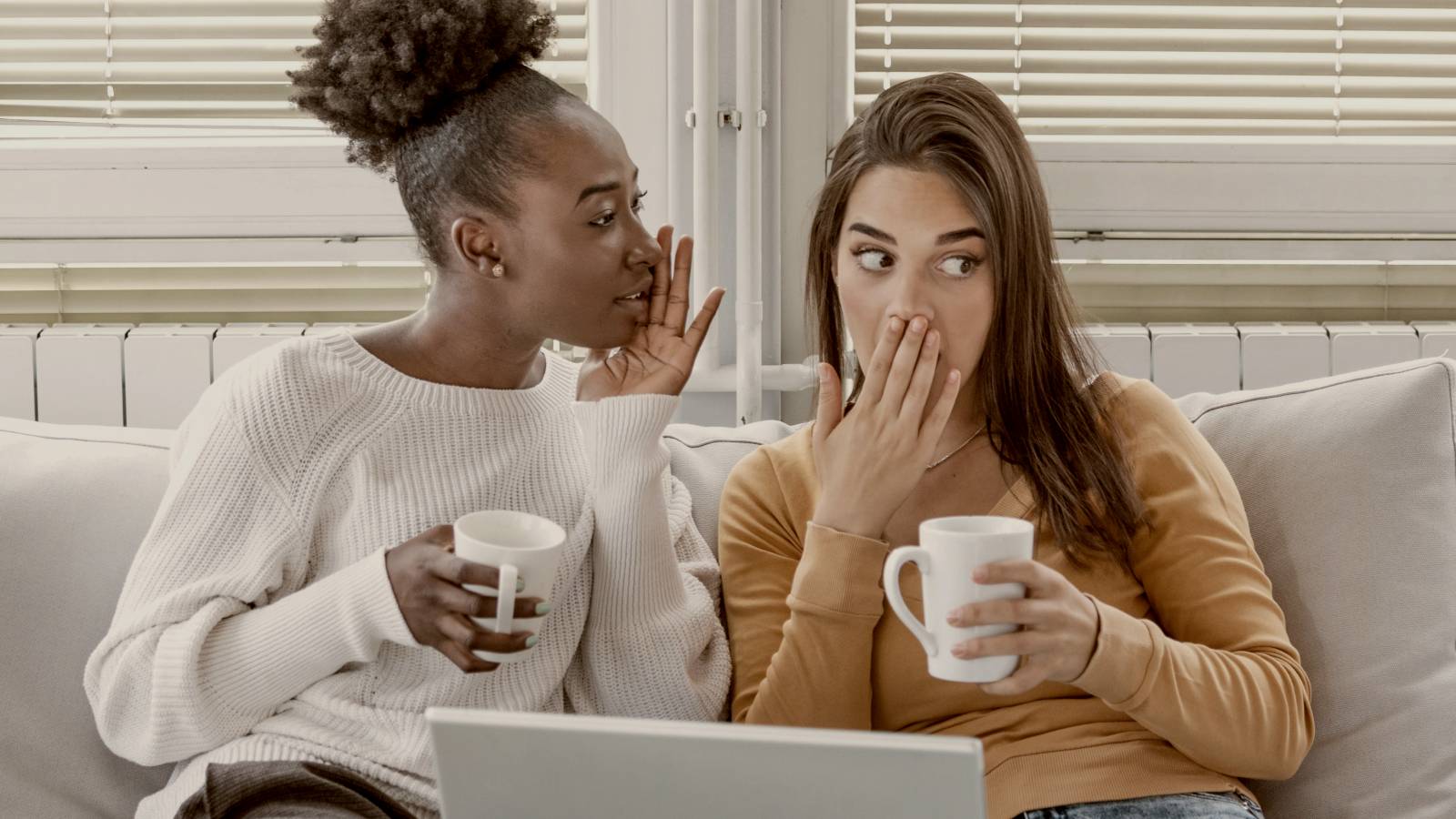 
two women gossiping at home holding mugs by Getty Images
